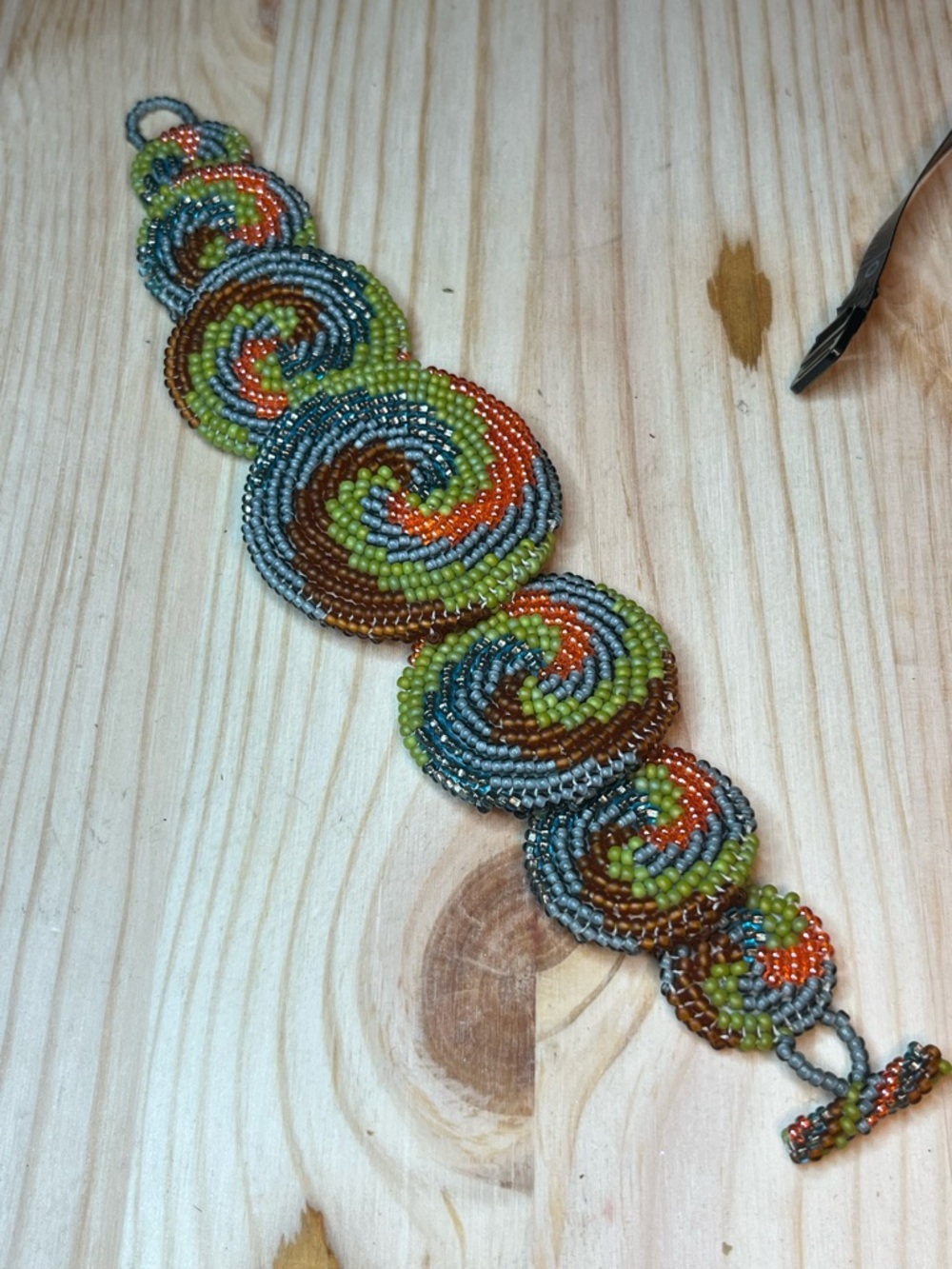 Handmade cuff bracelet with a tribal-inspired geometric spiral pattern